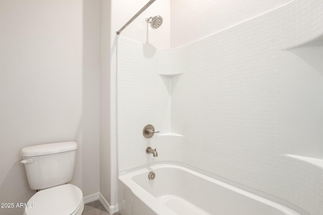 bathroom with toilet and tiled shower / bath combo