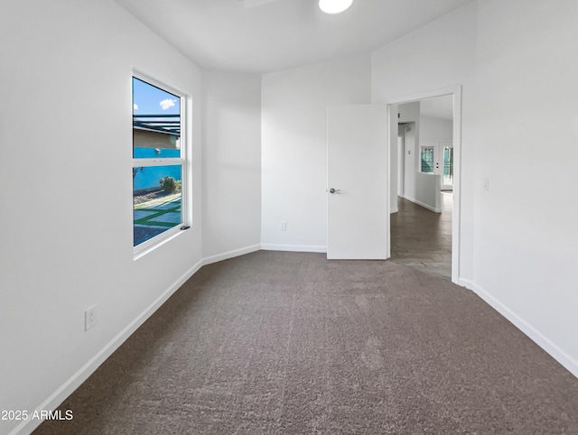 spare room featuring dark colored carpet