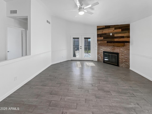 unfurnished living room with a fireplace, ceiling fan, french doors, and lofted ceiling