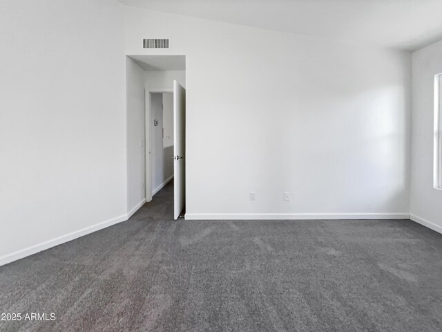 carpeted empty room featuring vaulted ceiling