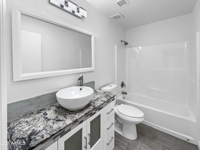 full bathroom featuring shower / washtub combination, vanity, hardwood / wood-style floors, and toilet