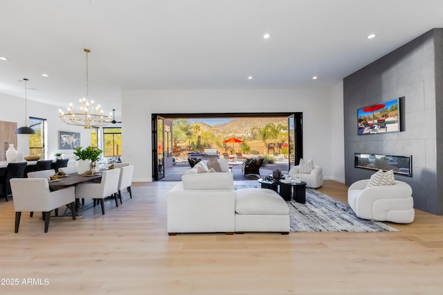 living room with a fireplace, a chandelier, and light hardwood / wood-style flooring