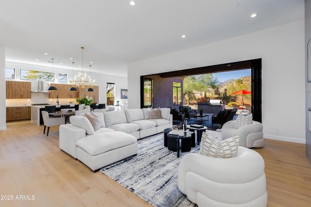 living room featuring a notable chandelier and light wood-type flooring