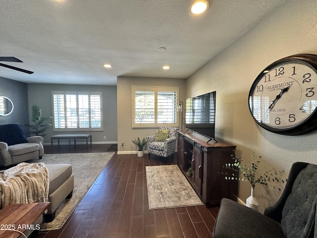 living room with ceiling fan, a wealth of natural light, and a textured ceiling