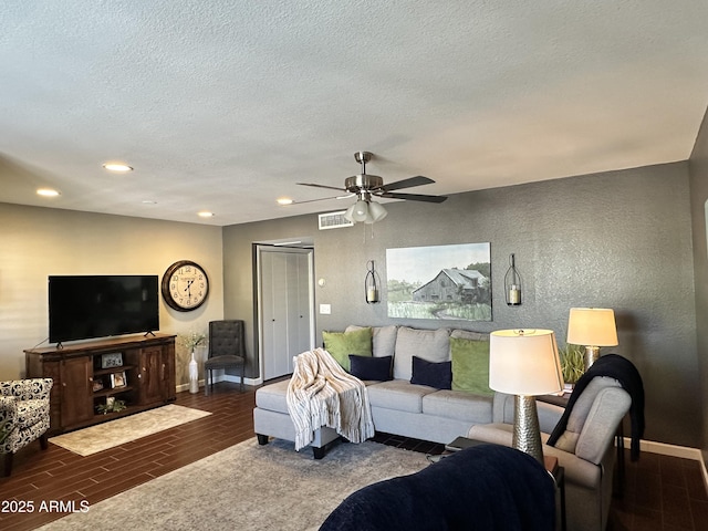 living room with a textured ceiling and ceiling fan