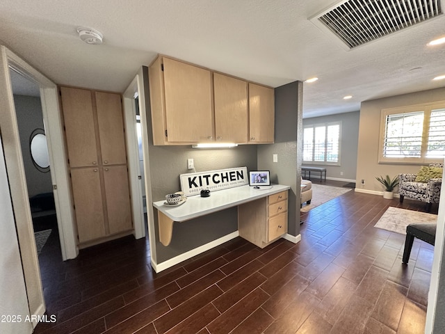 kitchen with built in desk, light brown cabinetry, and dark hardwood / wood-style flooring