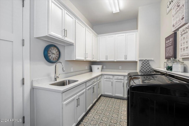 kitchen with white cabinetry, washer and clothes dryer, and sink