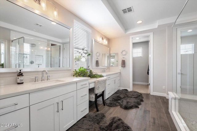 bathroom with hardwood / wood-style flooring, vanity, and an enclosed shower