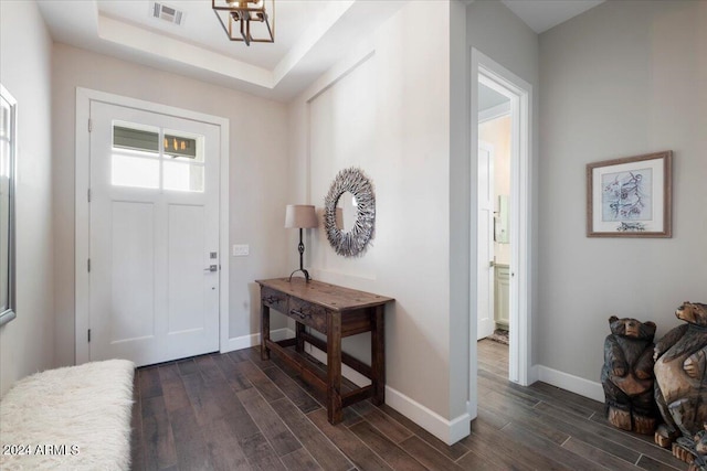 entrance foyer featuring dark hardwood / wood-style flooring and a tray ceiling