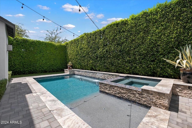 view of pool with pool water feature, an in ground hot tub, and a patio area