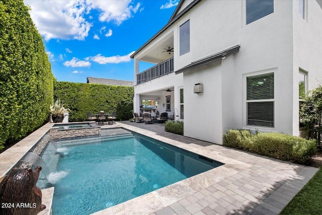 view of swimming pool with a patio, pool water feature, ceiling fan, and an in ground hot tub