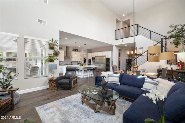 living room featuring high vaulted ceiling, dark wood-type flooring, and a chandelier