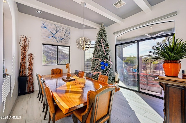 dining space featuring a notable chandelier, beam ceiling, and light wood-type flooring