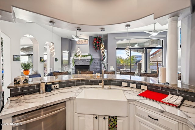 kitchen with white cabinetry, a wealth of natural light, pendant lighting, and stainless steel dishwasher