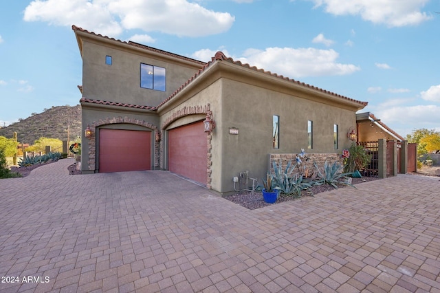 view of side of property with a mountain view and a garage