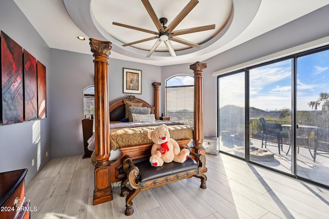 bedroom with access to outside, a raised ceiling, ceiling fan, and light hardwood / wood-style floors