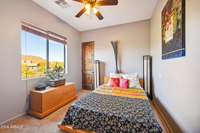 carpeted bedroom with ceiling fan and a mountain view