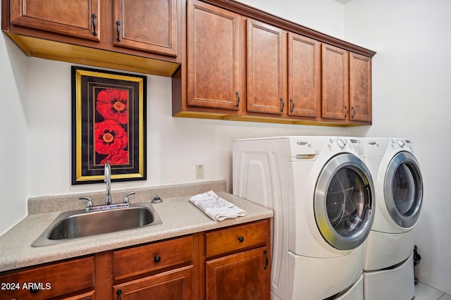 laundry area featuring washer and clothes dryer, sink, and cabinets