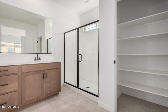 bathroom featuring walk in shower, vanity, and a wealth of natural light