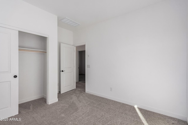 unfurnished bedroom with light colored carpet and a closet