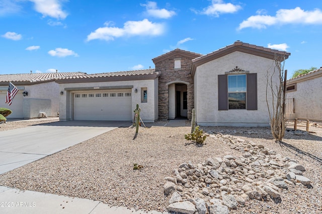 view of front of home featuring a garage, stone siding, stucco siding, a tiled roof, and driveway