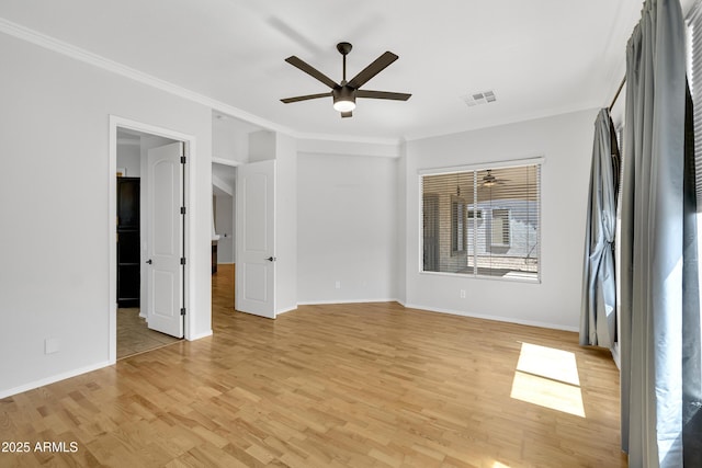 empty room featuring baseboards, a ceiling fan, light wood-style flooring, and ornamental molding