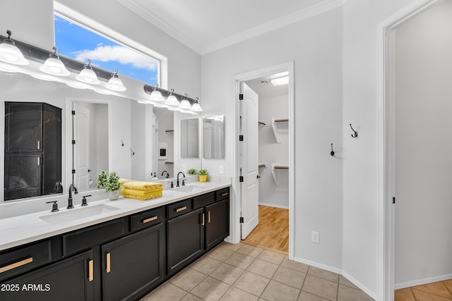 full bathroom with crown molding, a walk in closet, a sink, tile patterned flooring, and double vanity