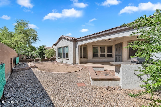 rear view of property with a patio, a fenced backyard, stucco siding, a ceiling fan, and a tiled roof