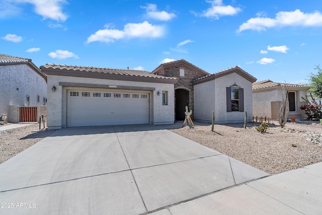 mediterranean / spanish-style home with an attached garage, stucco siding, driveway, and a tiled roof
