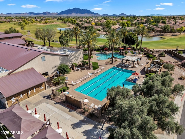 drone / aerial view with a water and mountain view, golf course view, and a residential view