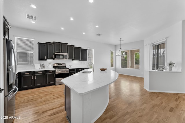 kitchen with dark cabinetry, stainless steel appliances, and visible vents