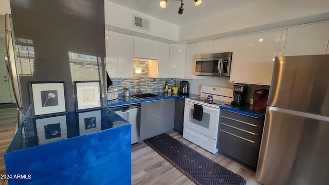 kitchen featuring dark countertops, visible vents, appliances with stainless steel finishes, white cabinets, and a sink