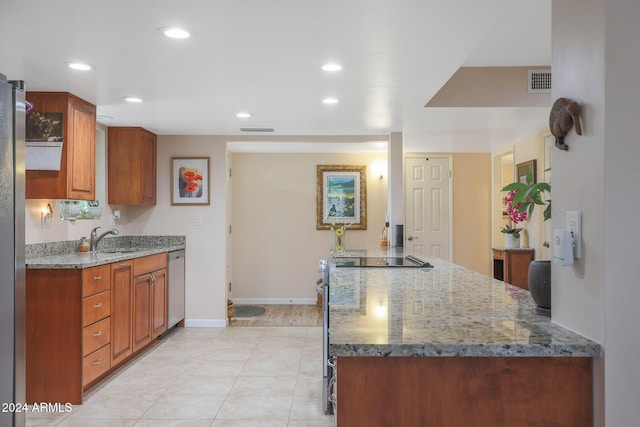 kitchen with stone counters, sink, stainless steel dishwasher, light tile patterned floors, and kitchen peninsula