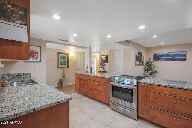 kitchen with kitchen peninsula, light stone counters, sink, and stainless steel range with electric cooktop