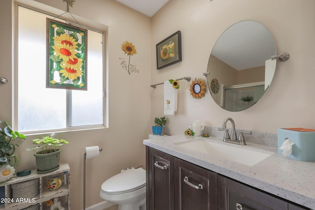 bathroom featuring vanity, toilet, and a shower with door