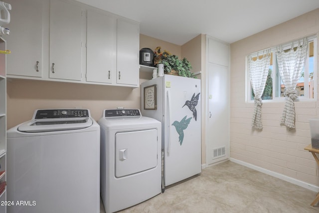 laundry room with washer and dryer and cabinets