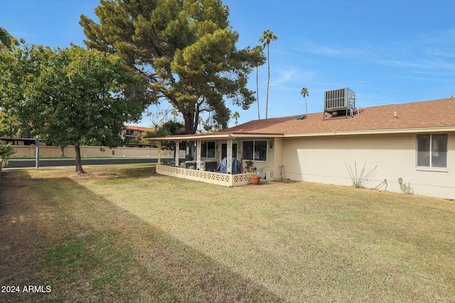 back of property featuring a lawn and cooling unit