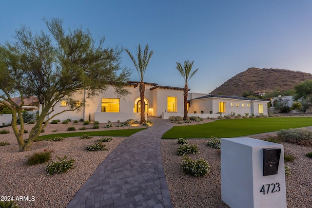 view of front of property with a mountain view and a front lawn