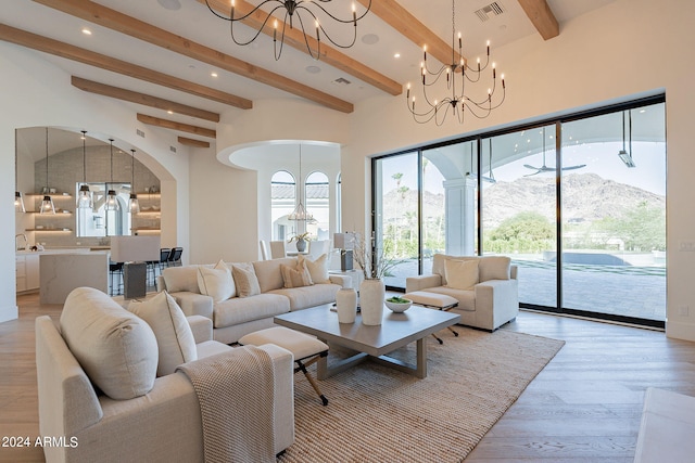 living room with sink, a chandelier, beamed ceiling, a mountain view, and light hardwood / wood-style floors