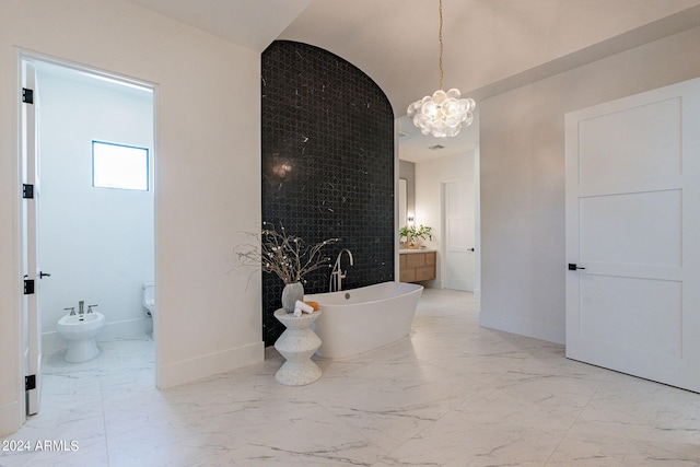 bathroom featuring a notable chandelier, a tub to relax in, a bidet, vaulted ceiling, and vanity