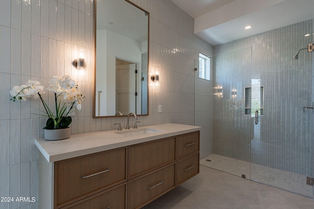 bathroom featuring tile patterned floors, vanity, tile walls, and walk in shower