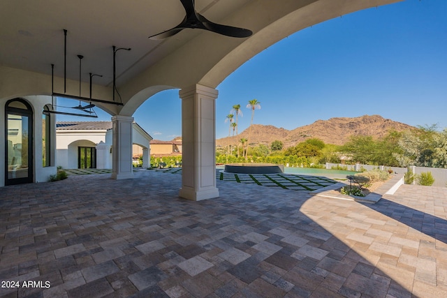 view of patio with ceiling fan and a mountain view