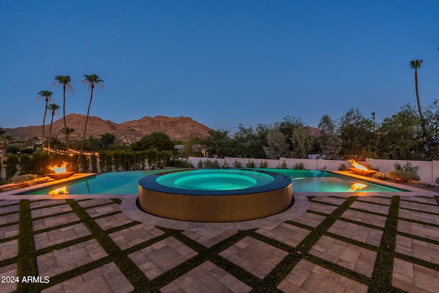 view of pool with a mountain view and an in ground hot tub