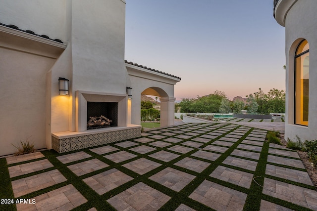 patio terrace at dusk with a tile fireplace