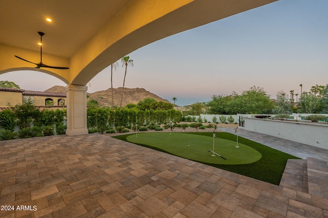 patio terrace at dusk with a mountain view and ceiling fan