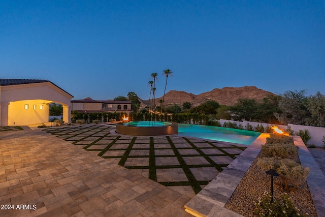 view of swimming pool with a mountain view, a patio, and an in ground hot tub