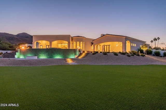 view of front of home featuring a mountain view and a yard