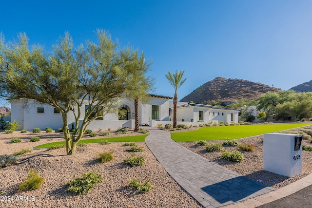 mediterranean / spanish house with a mountain view and a front lawn