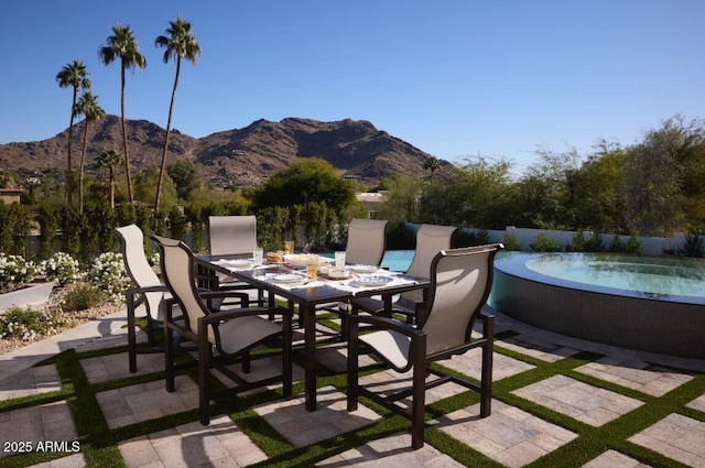 view of patio / terrace with a mountain view and a hot tub