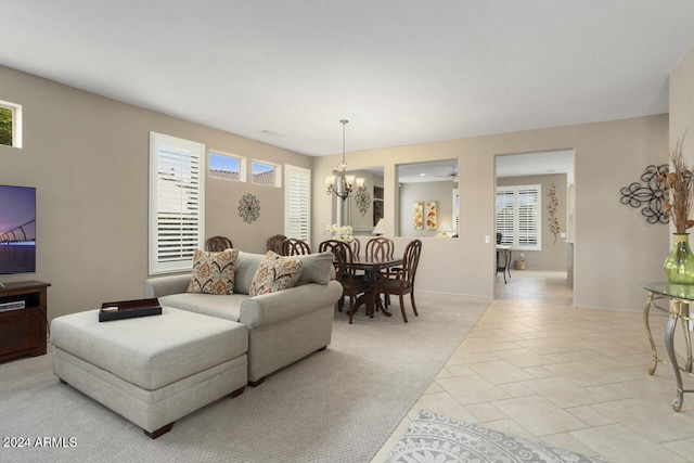 living room featuring light carpet, a healthy amount of sunlight, and a notable chandelier